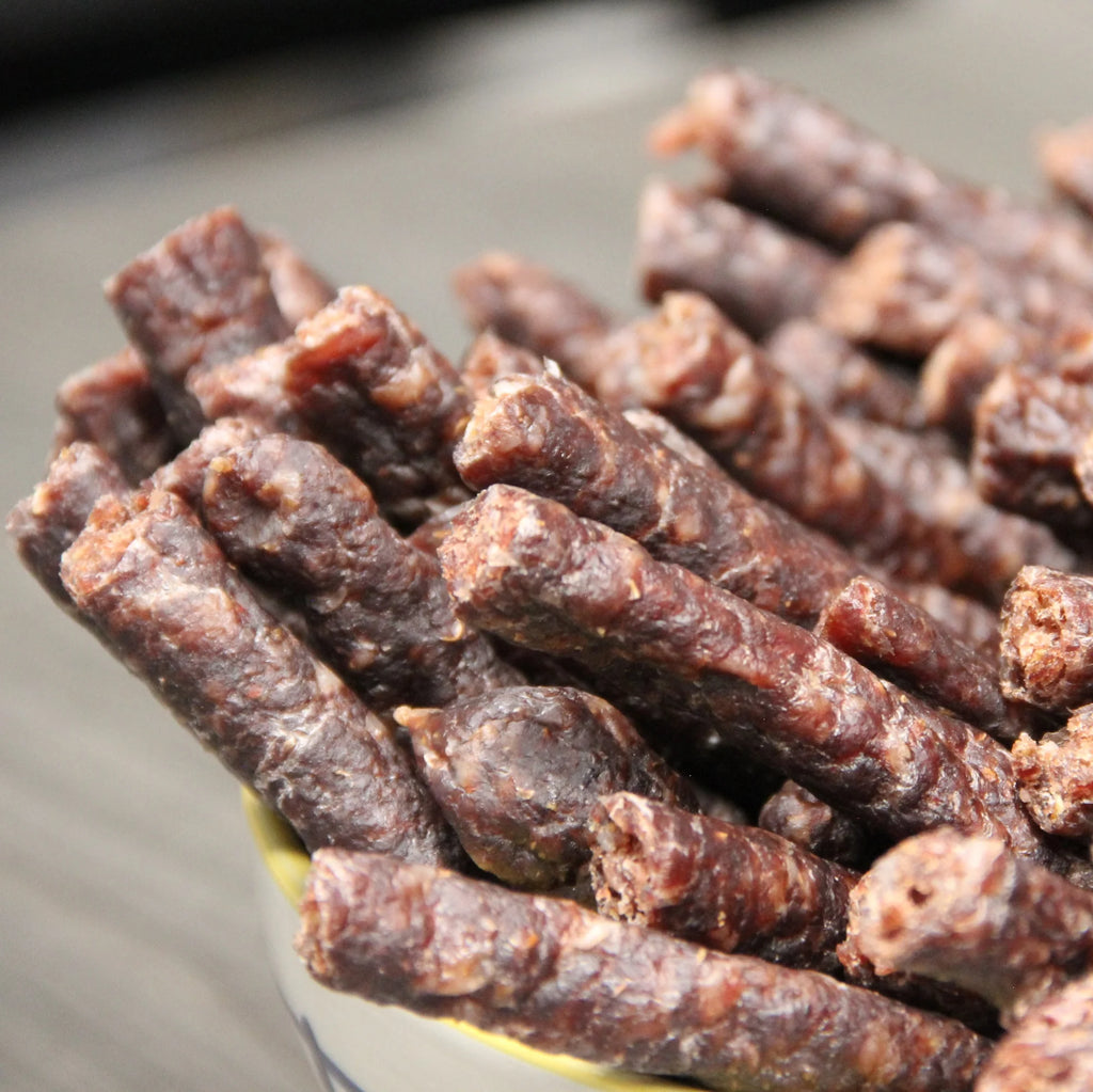 Close-up of Raw Sintra droëwors sticks piled in a bowl